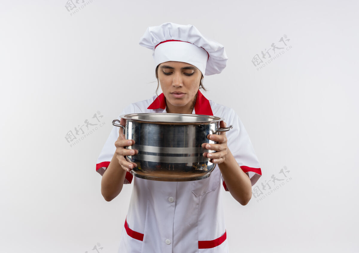 拿着想年轻的女厨师穿着厨师制服拿着一个看起来有复制空间的平底锅厨师穿着厨师