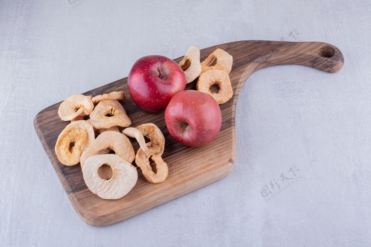 天然把干苹果片和整个苹果放在白色背景的木板上美味干燥有机