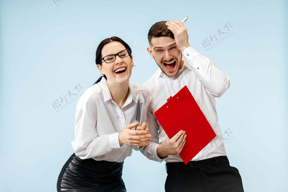 工人商业伙伴关系的概念年轻快乐微笑的男女站在工作室蓝色背景下肖像男人公司