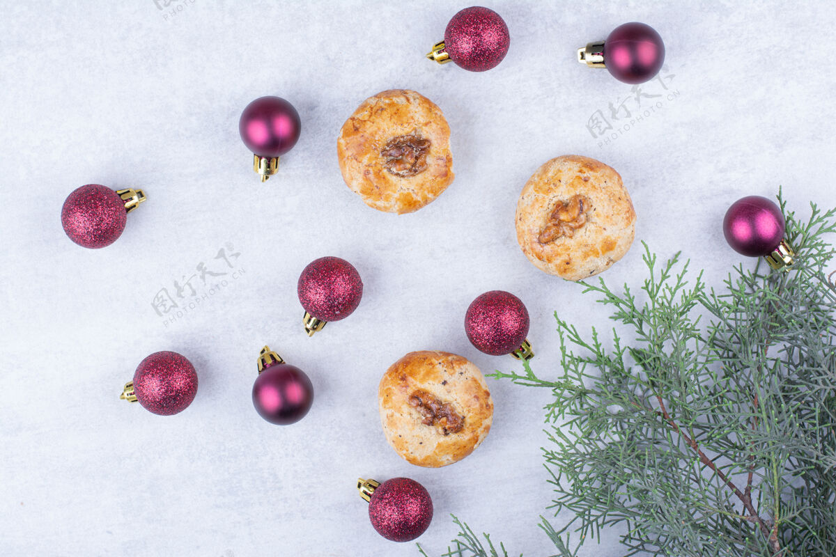 小吃核桃饼干和闪闪发光的圣诞球美味甜食树枝