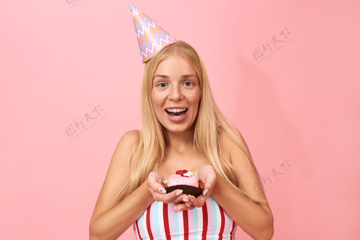 成人有雀斑 长直发 戴牙套的可爱迷人年轻女子的肖像向你祝贺生日蛋糕女性肖像