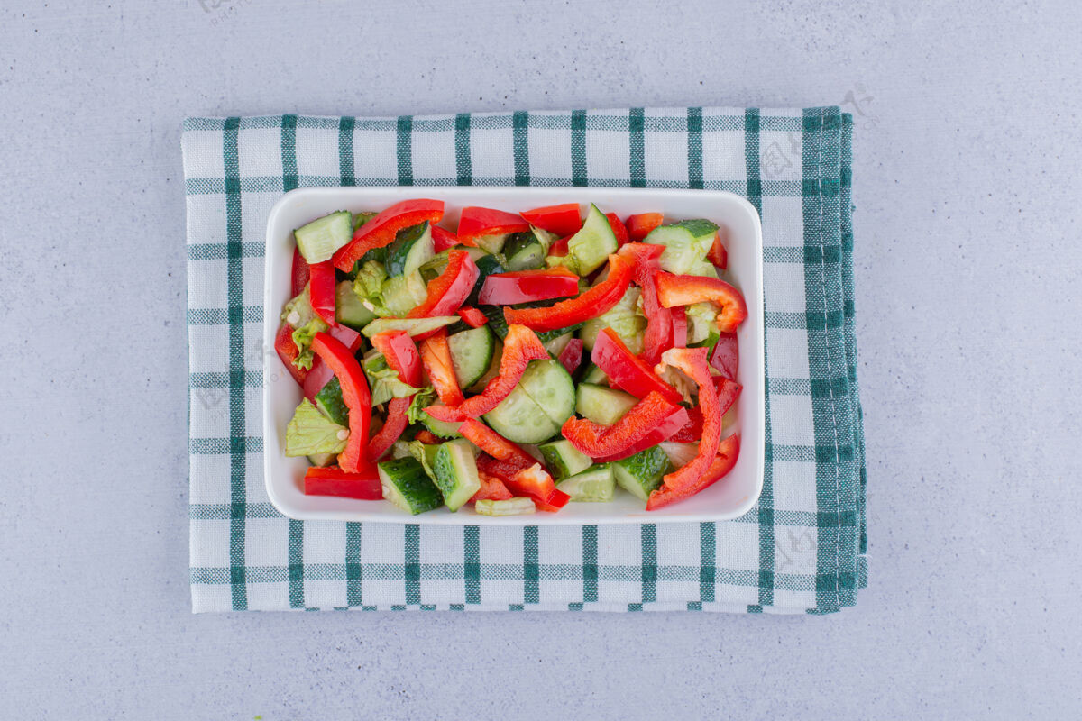 黄瓜在大理石背景上的桌布上放一盘蔬菜沙拉莴苣饮食拼盘