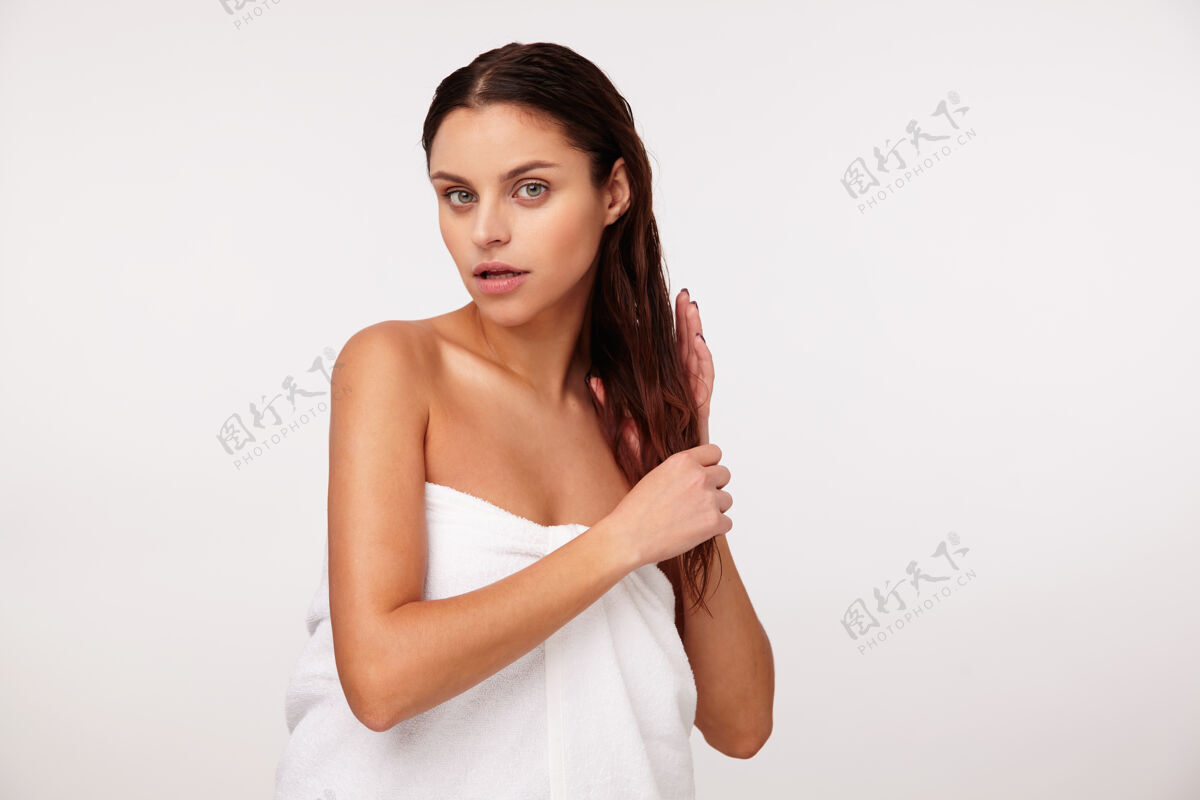 淋浴年轻迷人的黑发女士 裹着白色浴巾 手拿头发 淋浴后摆姿势马尾可爱心情