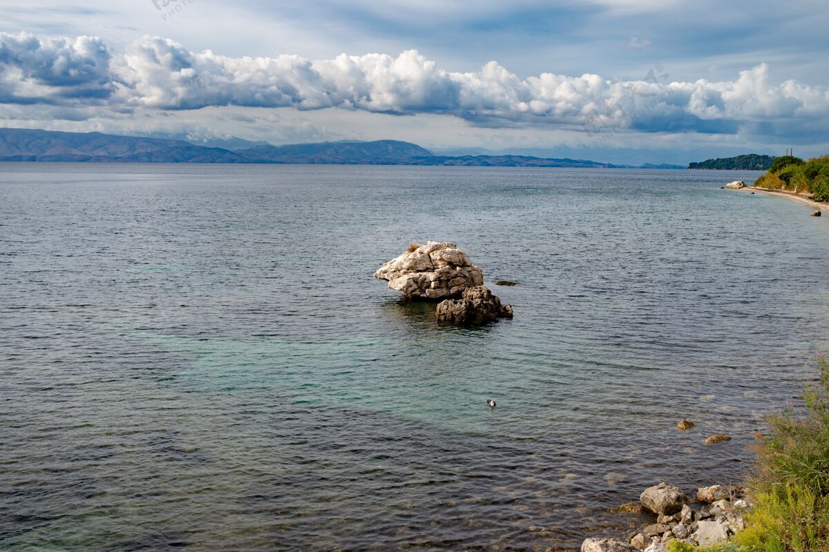 风景美丽的绿色海湾 清澈的海水 希腊科孚岛上的巨石 美丽的爱奥尼亚海滩 晴朗的天气 蔚蓝的天空海洋岩石海滩