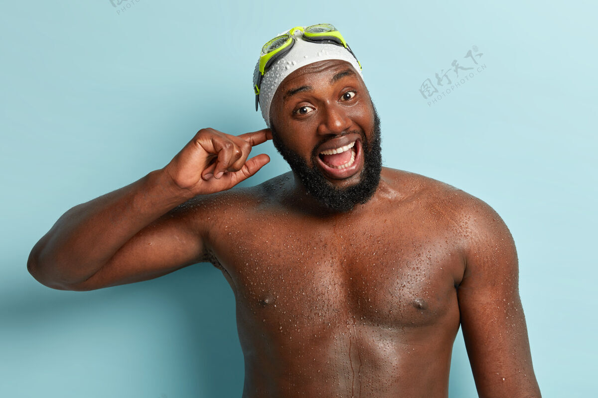 冠军半长镜头的快乐非洲裔美国男子潜水后耳朵进水 打湿深色皮肤 张大嘴巴积极大笑湿