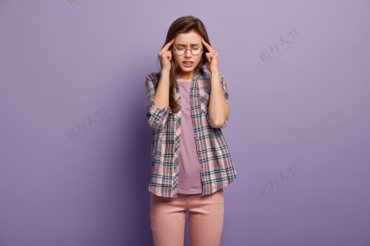 眼镜压力过大的过度劳累的女人总是把手指放在太阳穴上 患有头痛或偏头痛眼镜女性面部