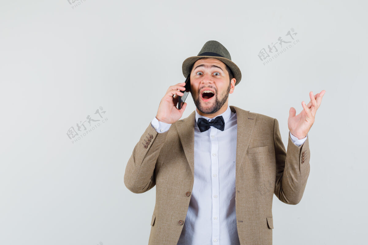 成人年轻人穿着西装 戴着帽子讲着手机 看上去很开心 正面照电话友好说话