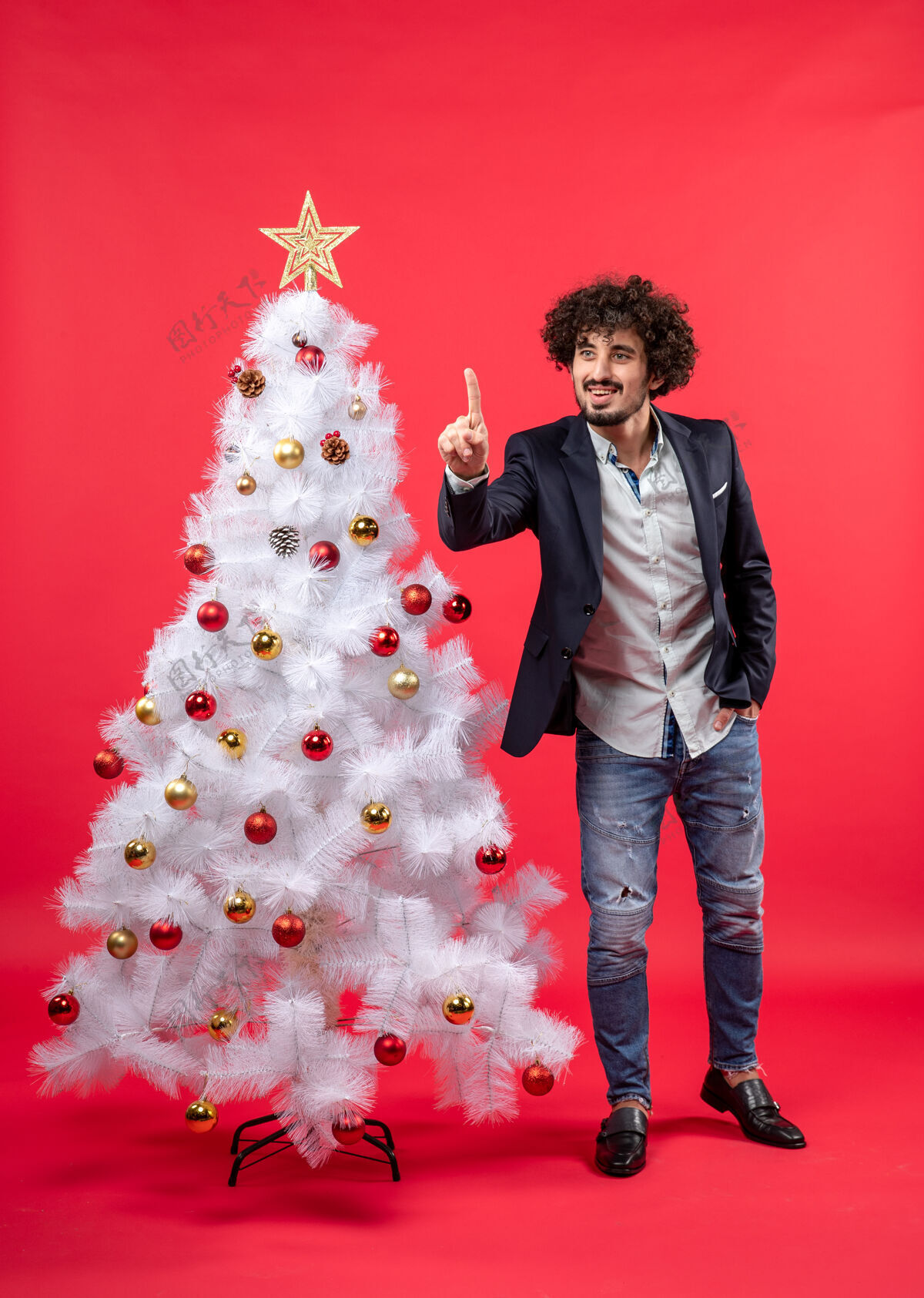 礼物圣诞庆典上 留着胡子的年轻人站在圣诞树旁展示圣诞树年轻乐趣快乐