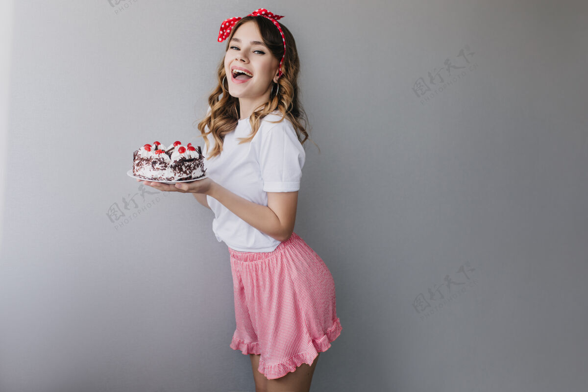 吃穿着浪漫服装的苗条白人女士摆出生日蛋糕的姿势派对前迷人女孩微笑的室内照片人模特自制