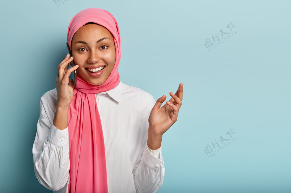正面开朗的阿拉伯女性有电话交谈 用手做手势 积极解释事情积极乐观高兴