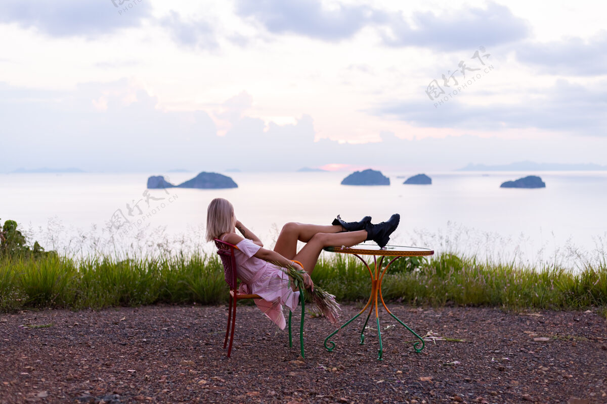 漂亮穿着夏装的年轻白种女人的浪漫写真 在山上的公园里享受着令人惊叹的热带海景配饰自然户外