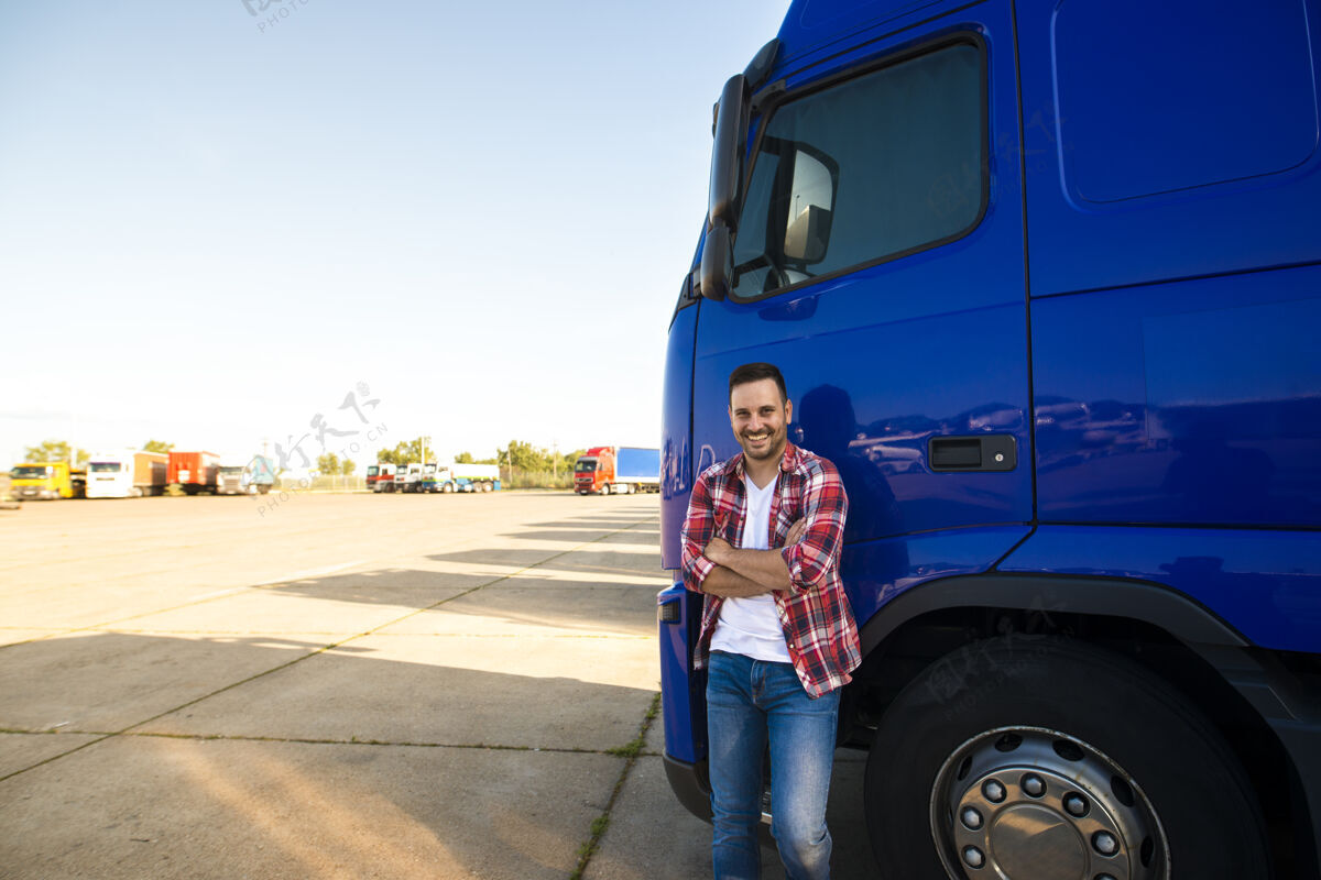 机舱微笑的卡车司机站在卡车旁准备开车的画像卡车司机道路现代