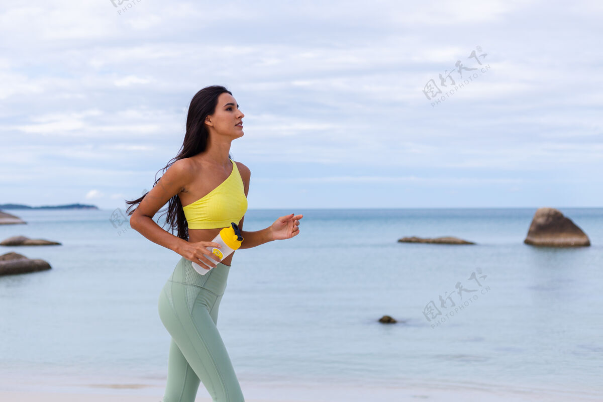 减肥海滩上穿着五颜六色运动服的迷人年轻女子海滩运动女性