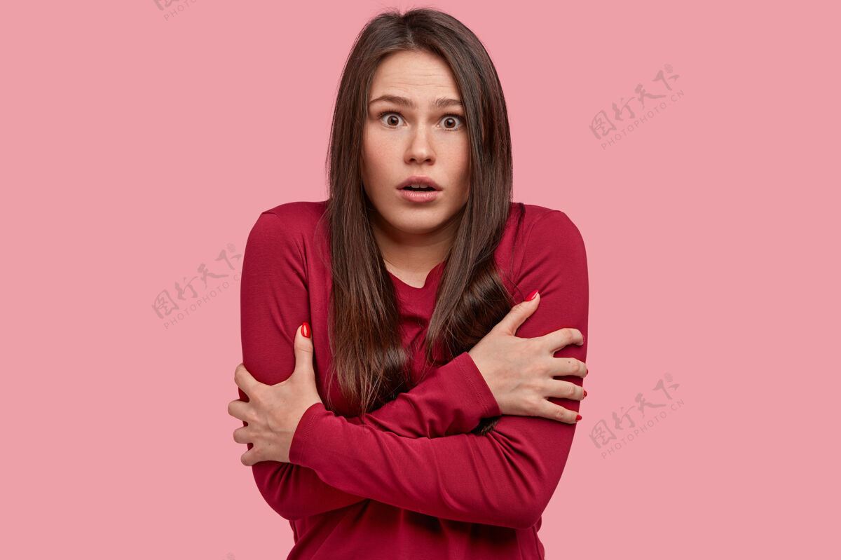 情绪化照片中的失意女子双手交叉放在胸前 吓得发抖 害怕惊骇的场面 穿着红衬衫表情姿势不满