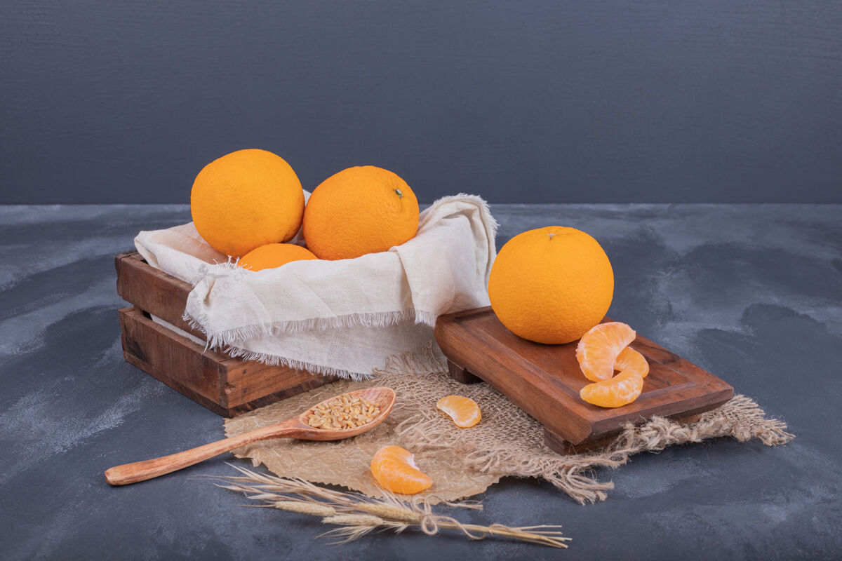 成熟新鲜的橘子放在木箱里 橘子片放在粗麻布上生天然木制
